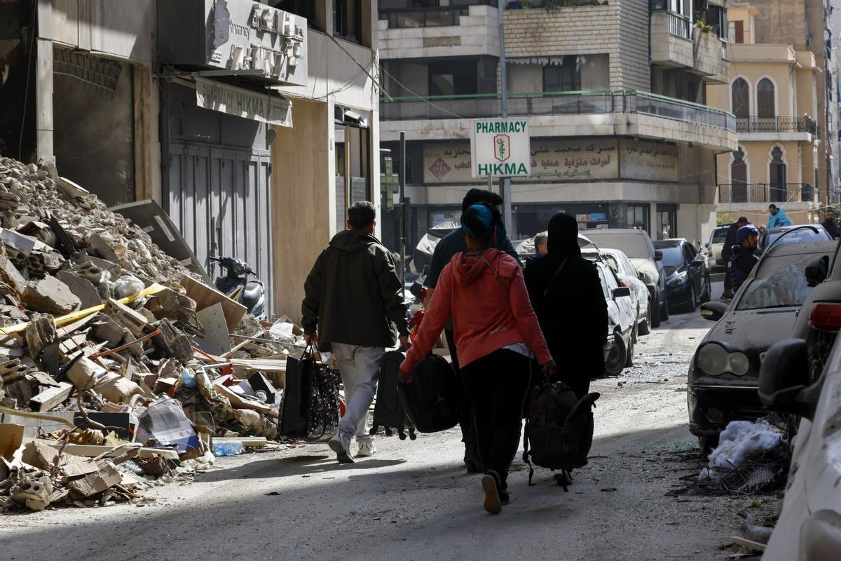 Un grupo de personas desplazadas carga con sus pertenencias tras un ataque israelí en un bloque de apartamentos en el centro de Beirut, el pasado martes.