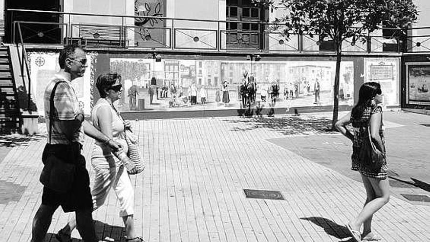 Paseantes, ayer, delante del mural de El Paseín.