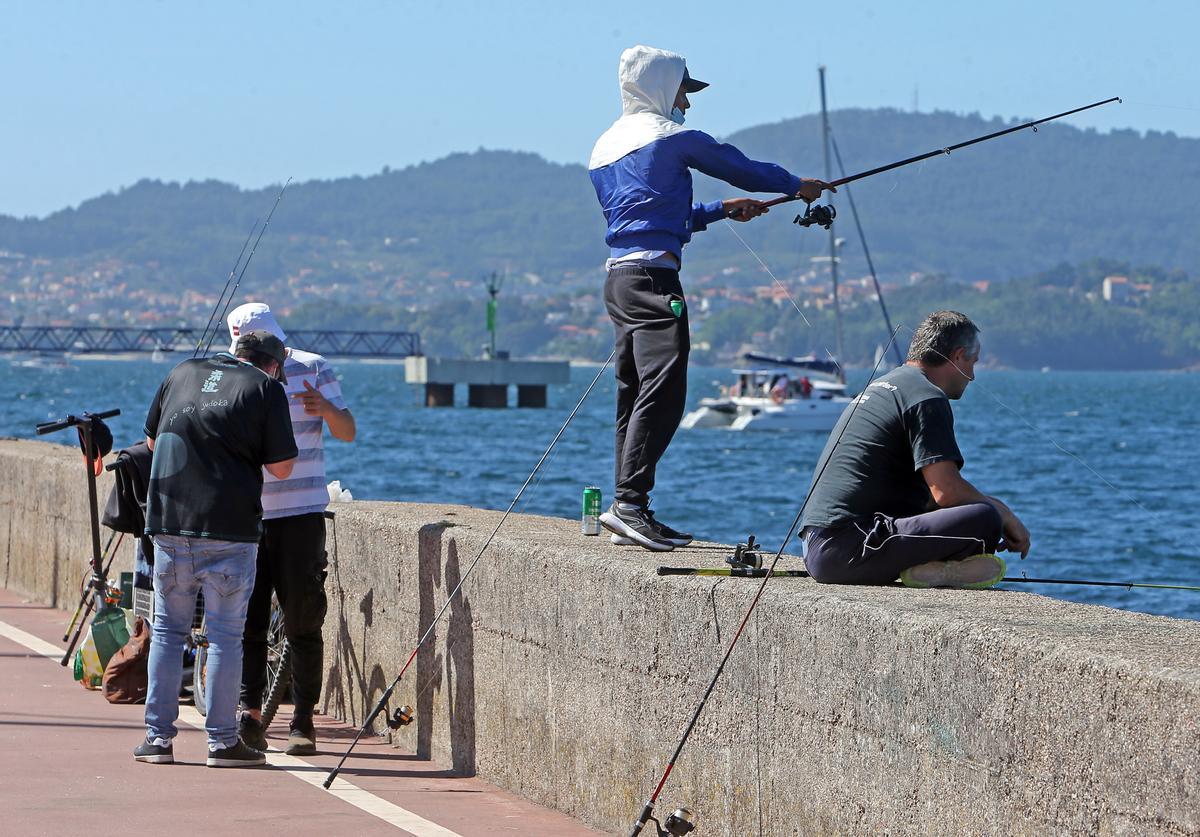 Un pescador recreativo lanza su caña al mar desde el puerto de Vigo.