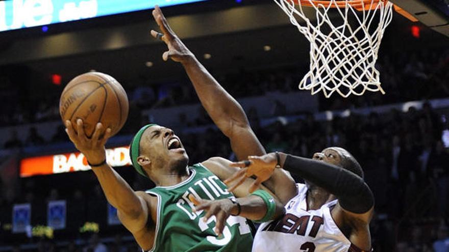 El jugador de los Heat  Dorell Wright trata de impedir la canasta de Paul Pierce, de los Celtics