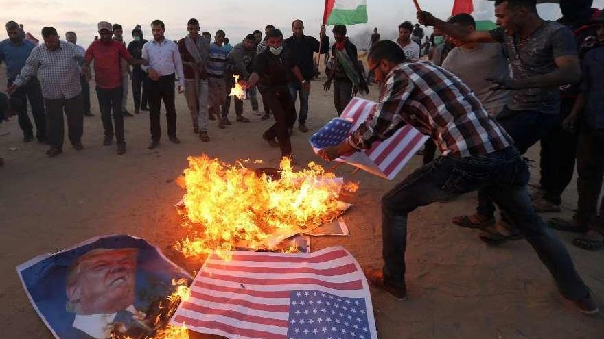 Manifestantes palestinos queman banderas de EE UU y fotos de Trump en la frontera de Gaza con Israel. . // Reuters