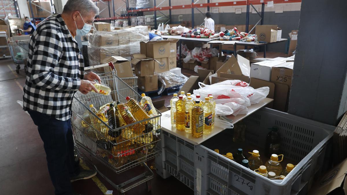 Un voluntario de un Banco de Alimentos organiza alguno de los productos donados para repartir entre personas necesitadas.