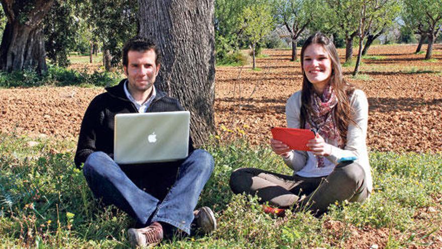 Los organizadores de Desintoxicación Digital, Miquel Lluís Mestre y Melissa del Cerro, en el campo conectados a las nuevas tecnologías.