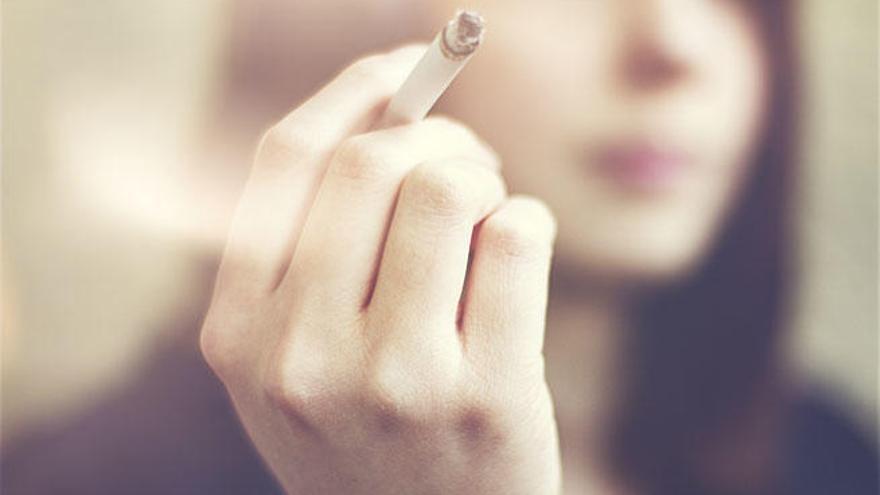 Una mujer fumando un cigarrillo.