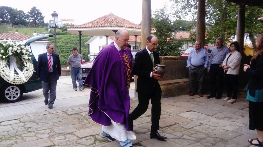 El hijo de Raúl Álvarez Obregón, Carlos Álvarez Laso, entra al templo con las cenizas de su padre acompañado del párroco, César Borbolla.