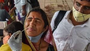 Una sanitaria hace una PCR a una mujer tras bajarse de un tren de larga distancia en Mumbai (India), el 9 de julio.