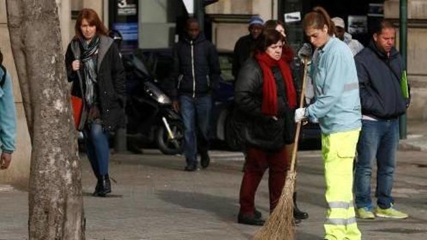 Dues escombriaires a peu netejant un carrer, en una imatge d&#039;arxiu.