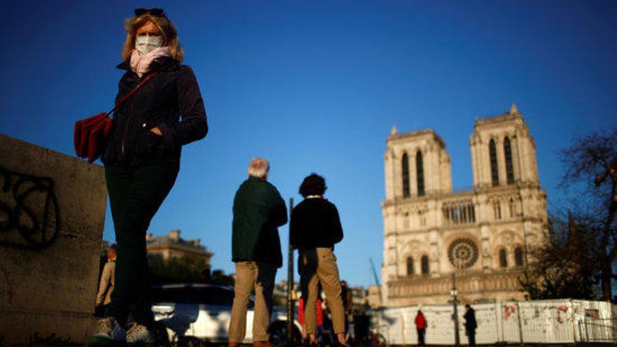 Gent amb mascaretes davant la catedral de Notre-Dame de Paris durant la pandèmia del coronavirus