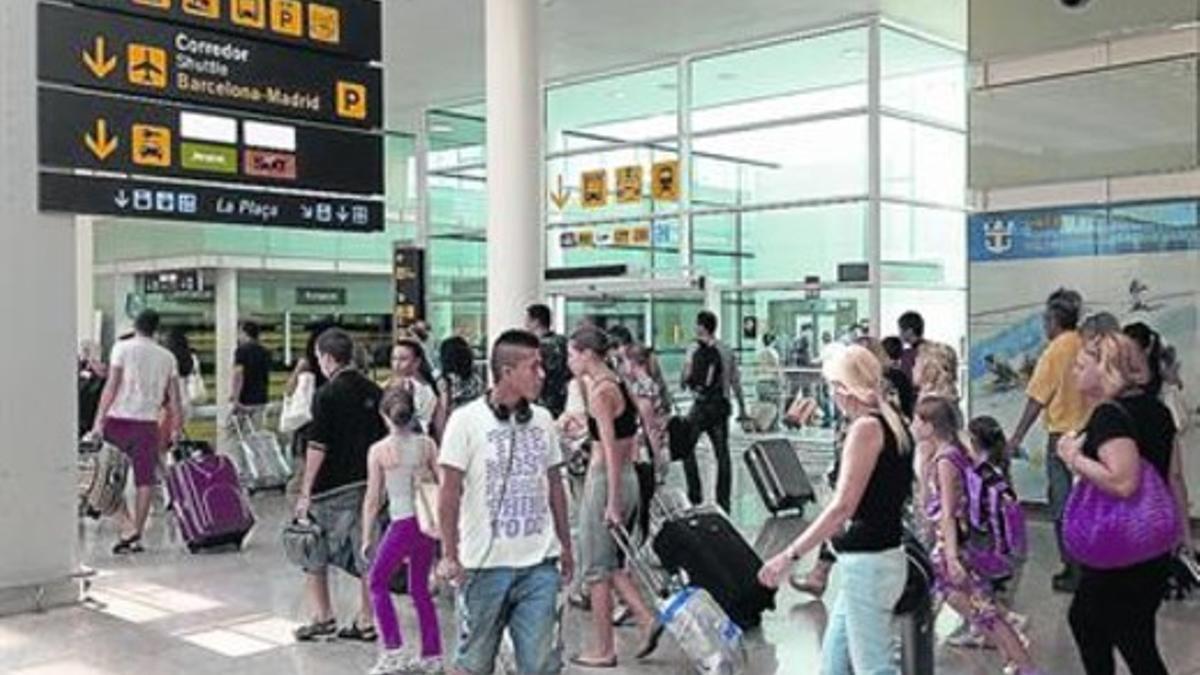 Numerosos viajeros transitan por las instalaciones de la T-1 del aeropuerto de El Prat, en julio del 2013.