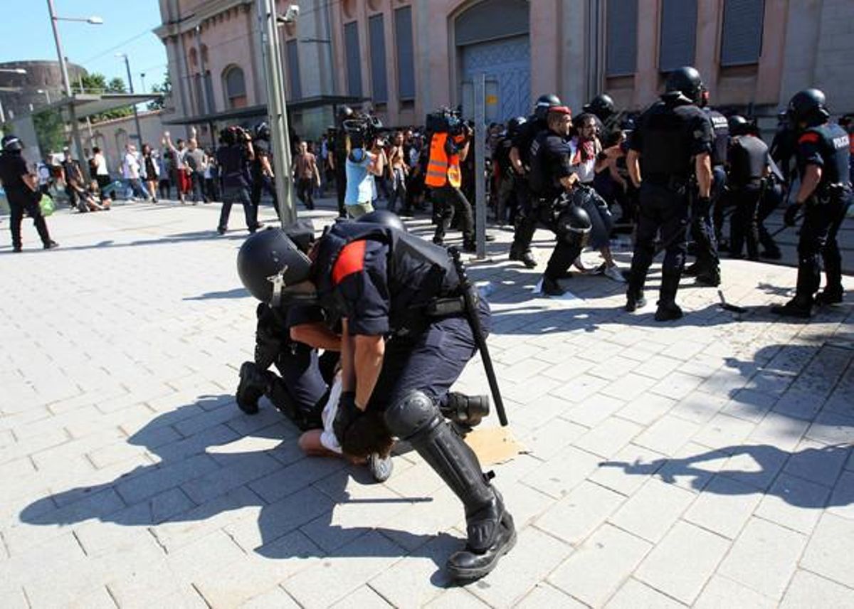 Dos agents immobilitzen una persona al carrer de Wellington cantonada amb el de Villena.