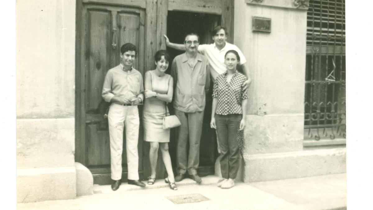 D’esquerra a dreta, Domènech Serneguet, desconeguda, Joan Fuster, Raimon i Annalisa Corti a la porta de la casa de Fuster. Autor desconegut, carrer de Sant Josep, 10, Sueca, 1967. 1977.