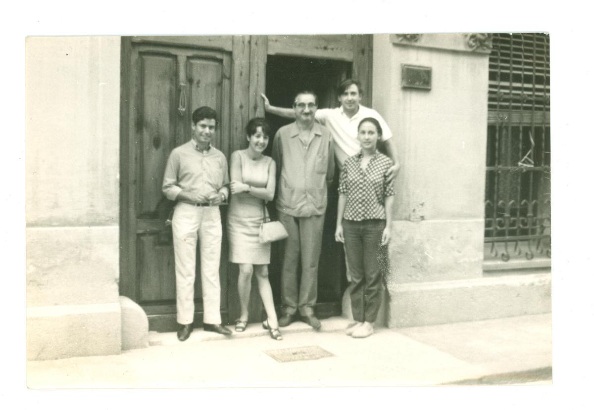 D’esquerra a dreta, Domènech Serneguet, desconeguda, Joan Fuster, Raimon i Annalisa Corti a la porta de la casa de Fuster. Autor desconegut, carrer de Sant Josep, 10, Sueca, 1967. 1977.