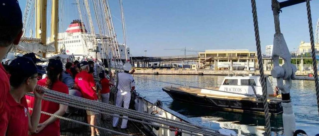 Un remolcador colabora en la maniobra del &quot;Creoula&quot; para abandonar el puerto de Málaga.