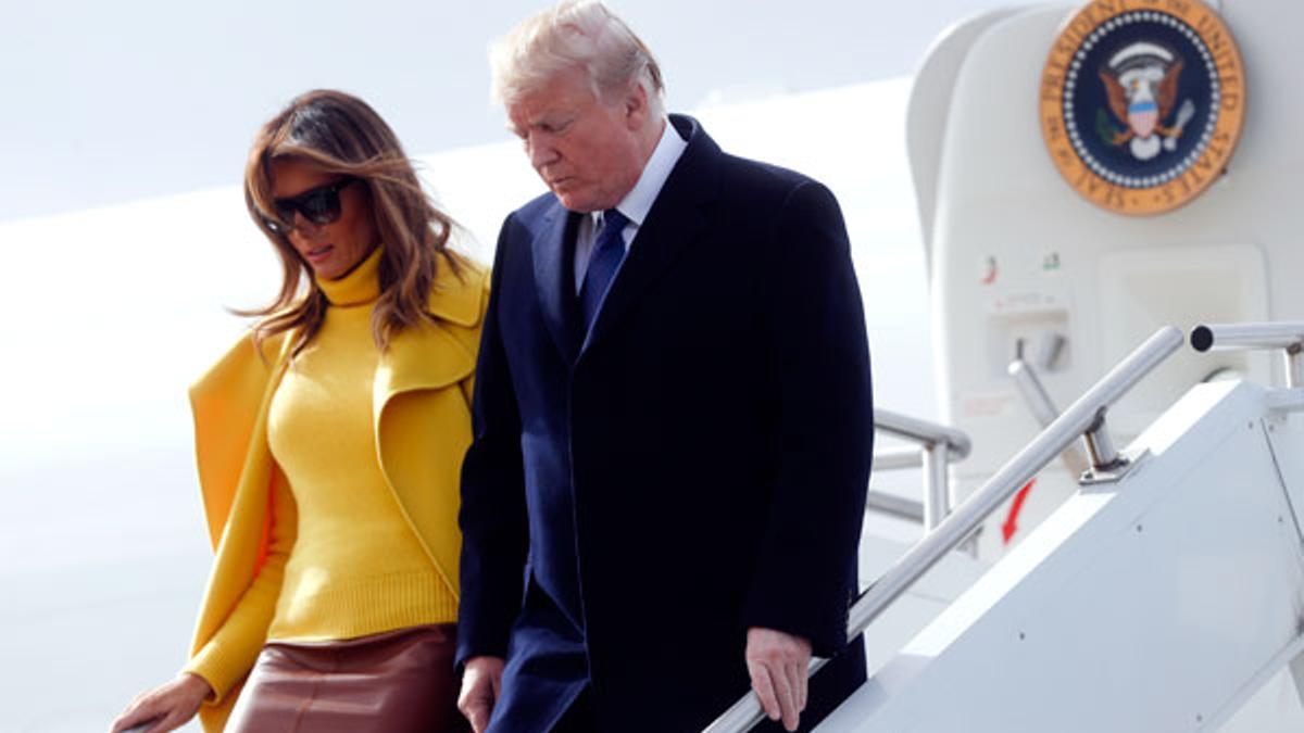 Melania Trump con jersey y abrigo amarillo junto a Donald Trump