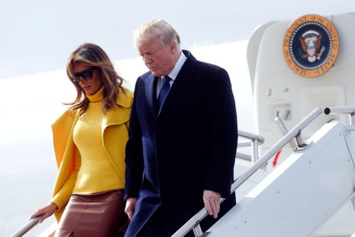 Melania Trump con jersey y abrigo amarillo junto a Donald Trump