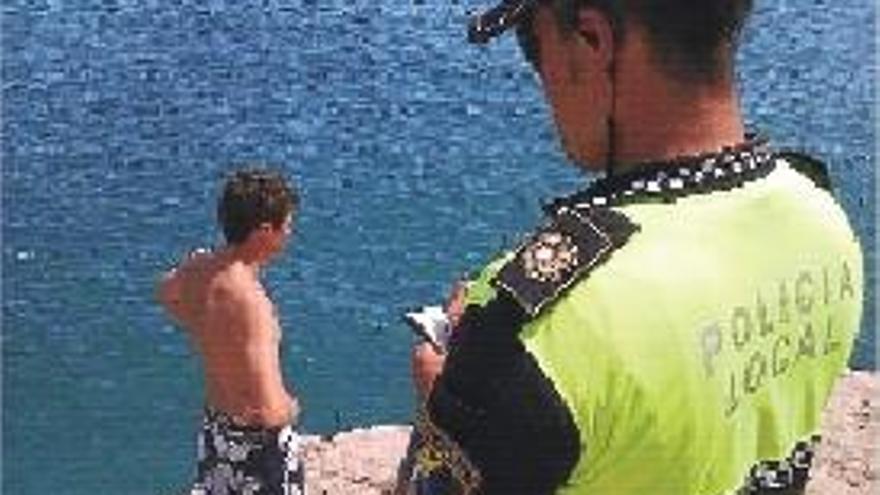 Un agente de la Policía Local sanciona a los jóvenes.