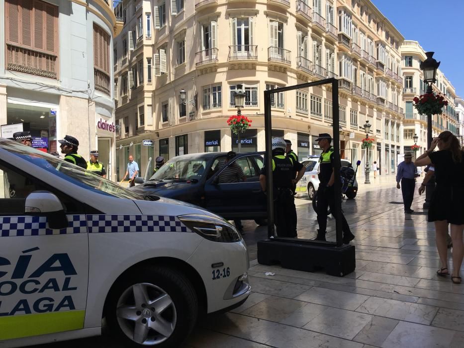 Detención de un hombre con su coche en la calle Larios.