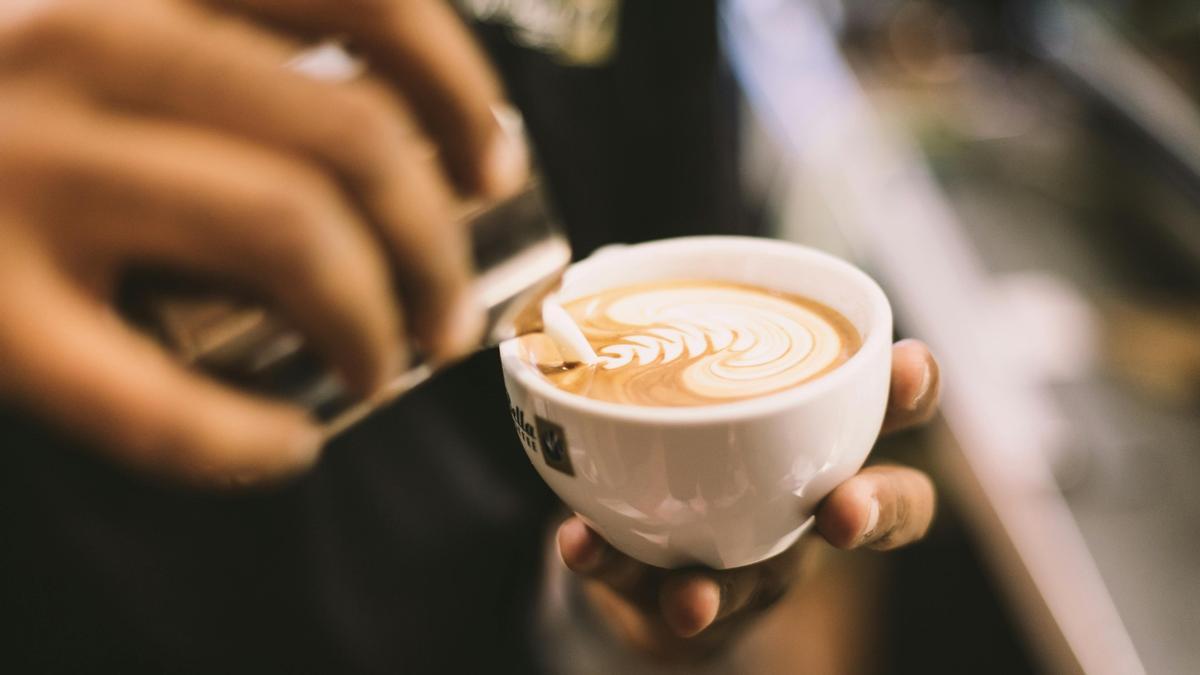 Una persona sirve un café con leche, en una imagen de archivo