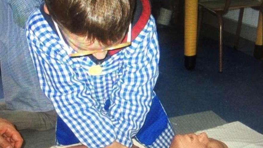 Un niño, realizando un simulacro de reanimación cardiopulmonar.