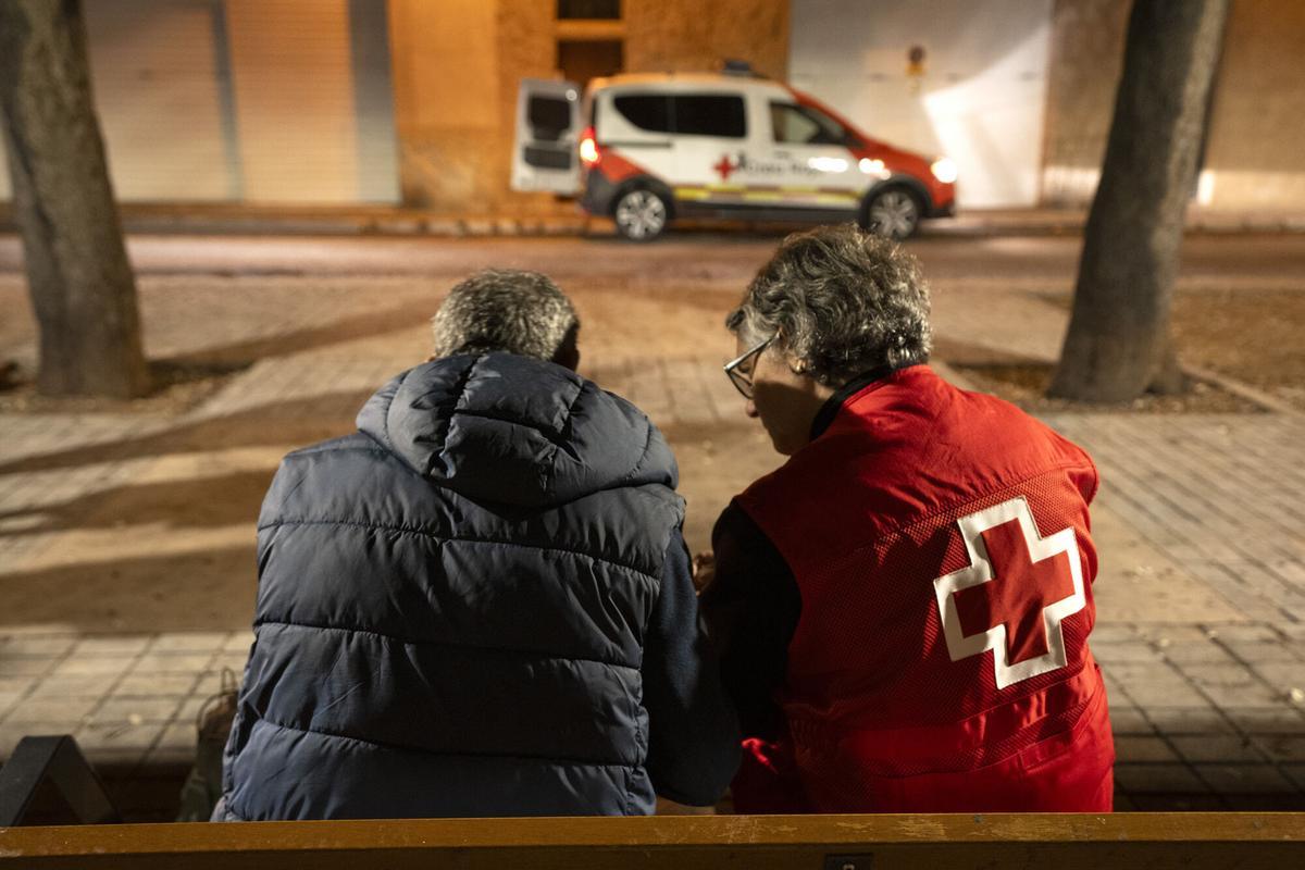 Una membre de la Creu Roja atenent una persona sense llar en una sortida nocturna a Figueres.