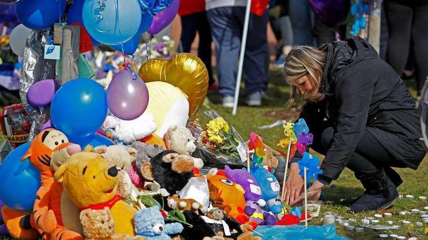 Una mujer, depositando flores ante un memorial dedicado a Alfie Evans frente al Hospital Alder Hey, ayer. En el recuadro, el niño británico en una foto tomada el pasado día 5.