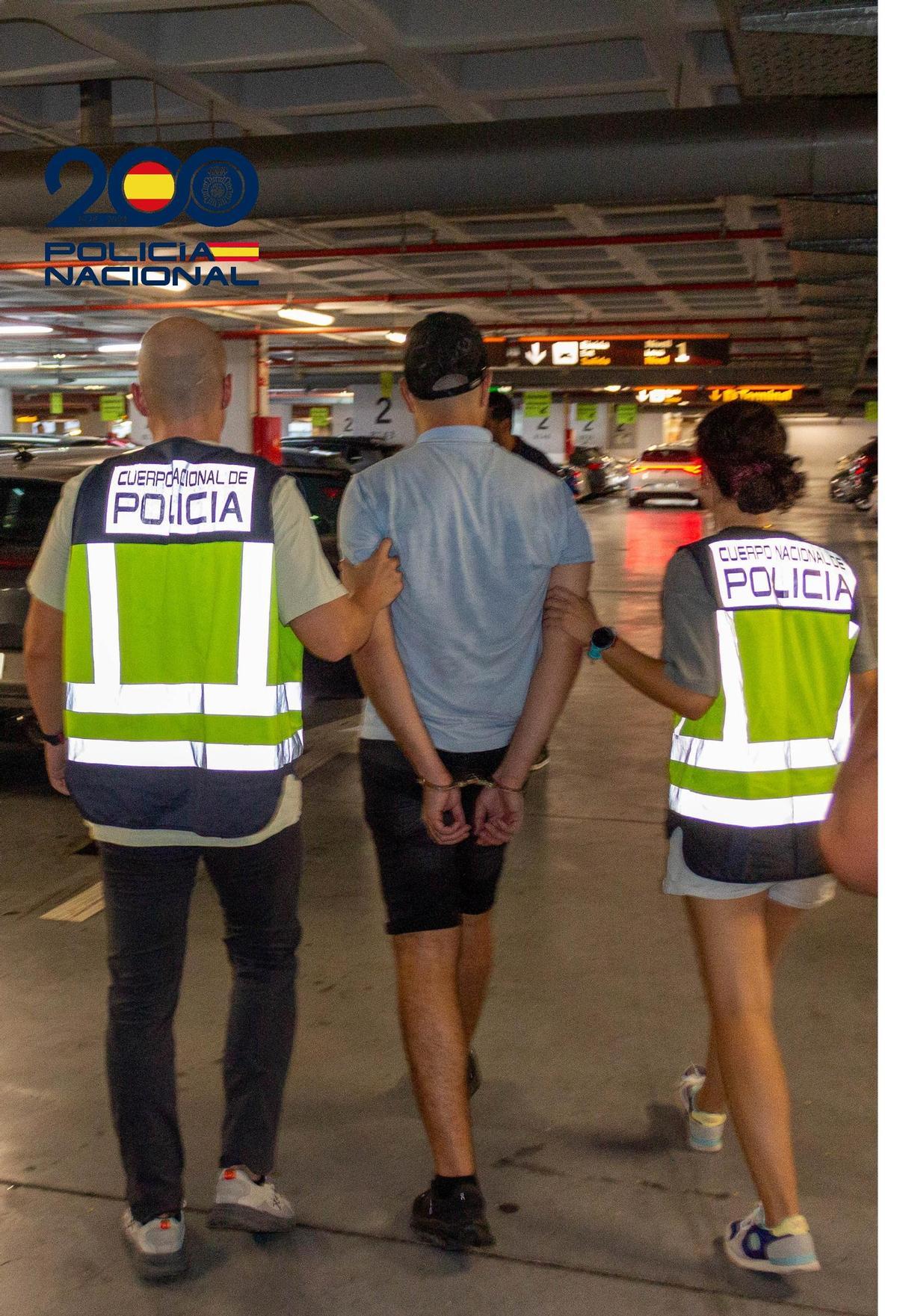 Dos agentes de la Policía Nacional acompañan al detenido a dependencias policiales.