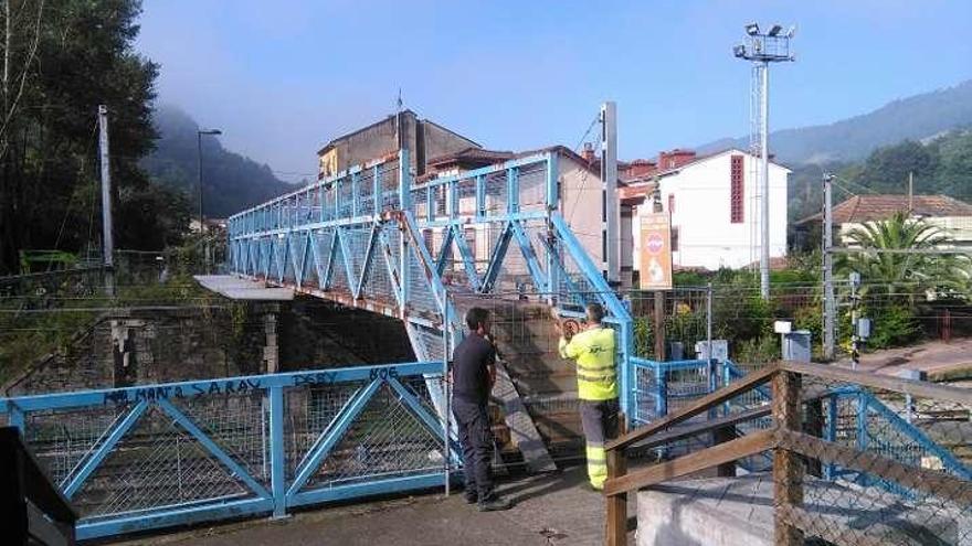 Operarios municipales, cerrando, ayer, el acceso a la pasarela.