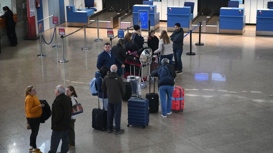 Viajeros ante los mostradores de facturación del aeropuerto de Alvedro. | // CARLOS PARDELLAS
