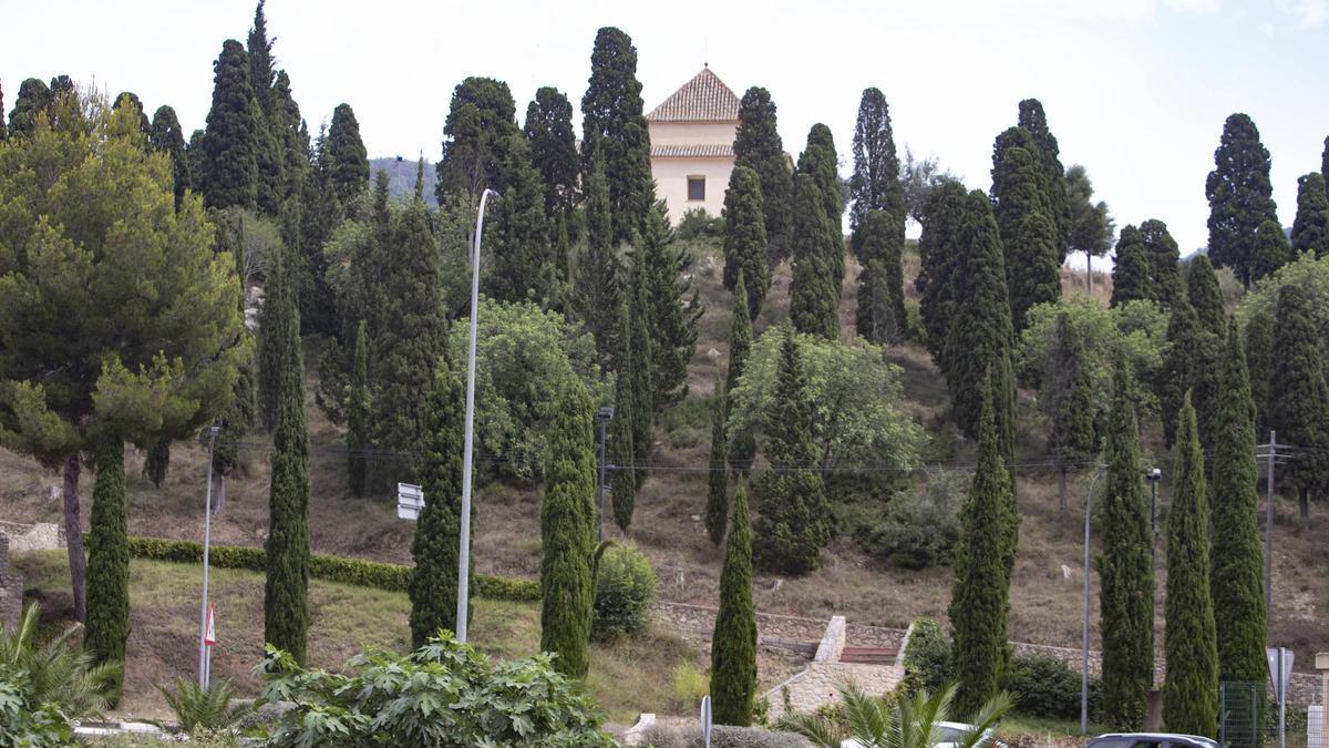 La ermita del Sant Crist del Mont Calvari del Genovés, arriba, rodeada de árboles.