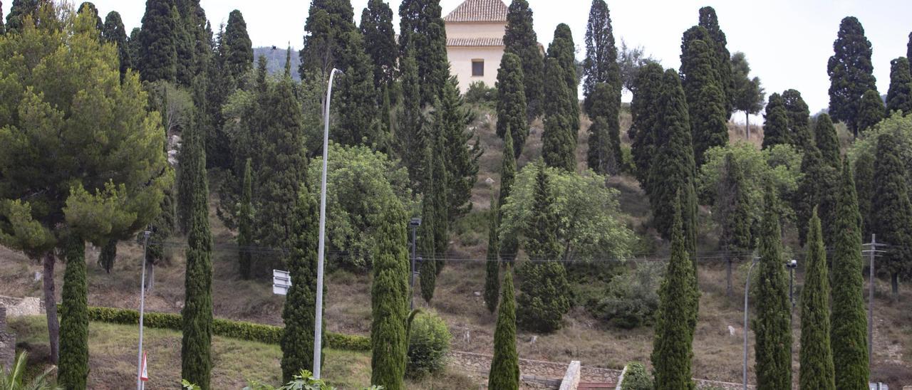 La ermita del Sant Crist del Mont Calvari del Genovés, arriba, rodeada de árboles.