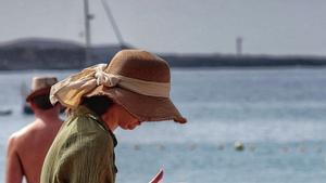 Una turista utiliza su móvil en una playa en el sur de Tenerife.  | MARÍA PISACA