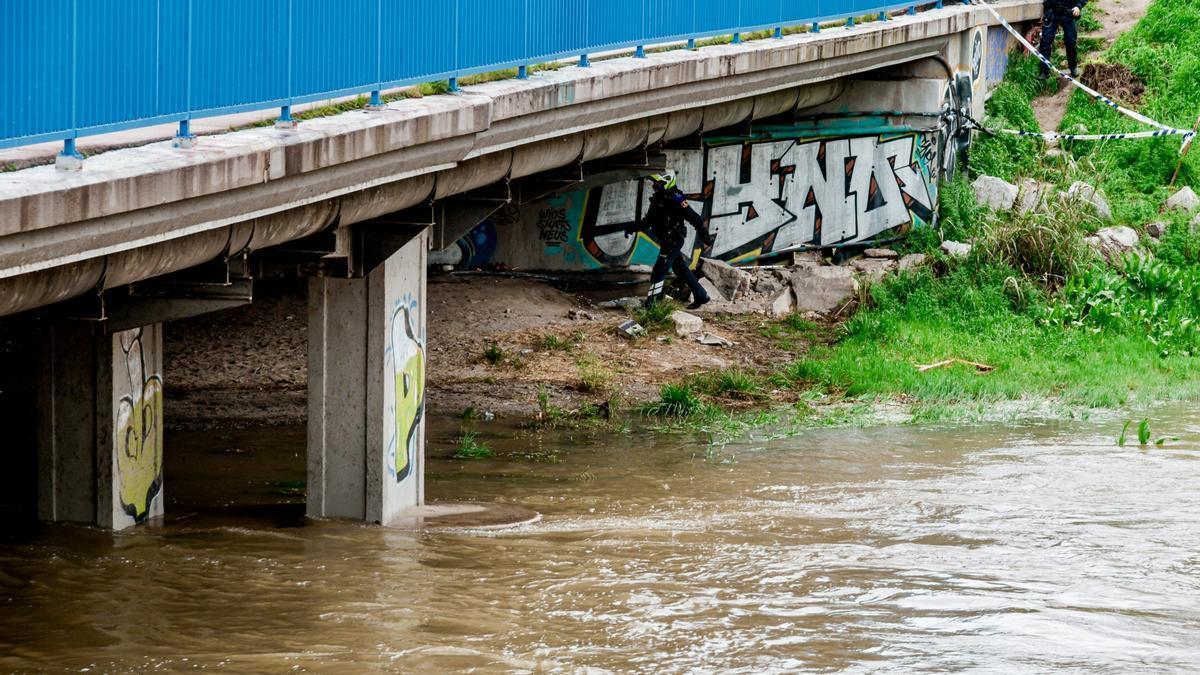 Dos agentes de la Policía Nacional en una de las orillas del Manzanares a su paso por el Puente de los franceses, este viernes por la mañana.