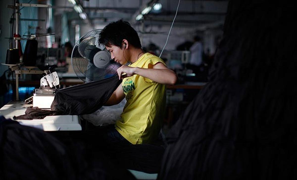 Un empleat treballa aquest dijous en una fàbrica xinesa de roba a Yiwu, província de Zhejiang. Les exportacions de la Xina han baixat lleugerament al maig com a conseqüència de la mala situació econòmica internacional.