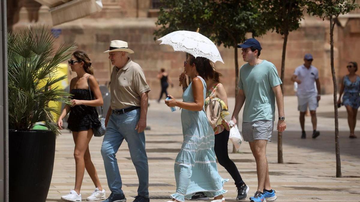 Turistas protegiéndose del calor en Málaga.