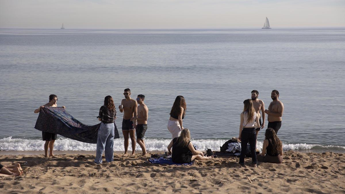 Bañistas y gente aprovechan este día de calor en invierno en la playa de la Barceloneta