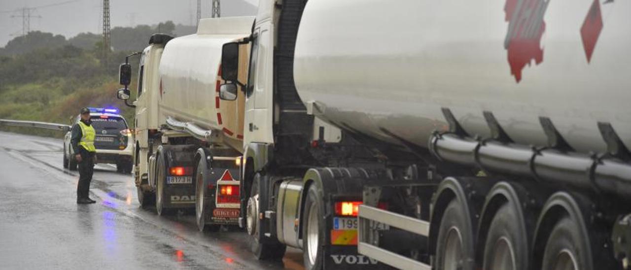 Un vehículo de la Guardia Civil abre paso a un convoy de cisternas para evitar el bloqueo de los piquetes.  Iván Urquízar