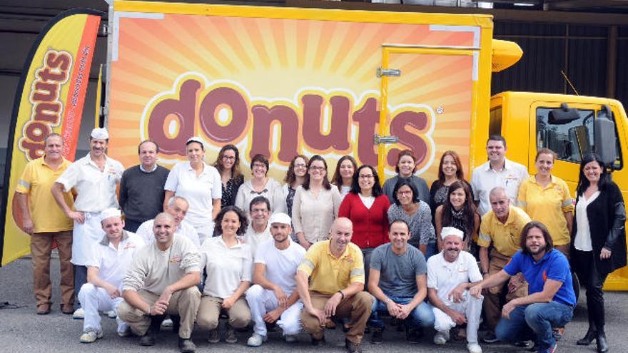 Miembros de la plantilla de Panrico Donuts Canarias, delante de un camión de reparto.
