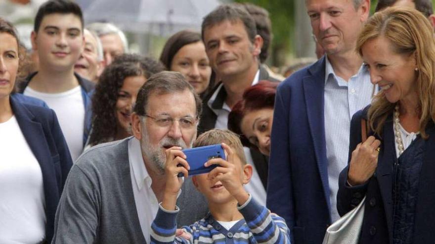 Rajoy se hace un &#039;selfie&#039; con un niño durante su paseo por la localidad coruñesa de Ordes.