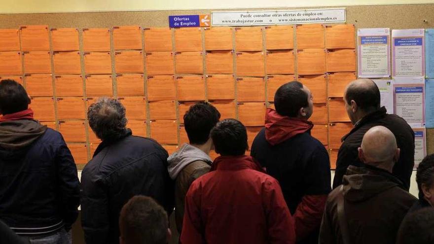 Un grupo de personas mira el tablón de anuncios con las ofertas de trabajo en una oficina del Servicio Público de Empleo del Principado (Sepepa) en Gijón.