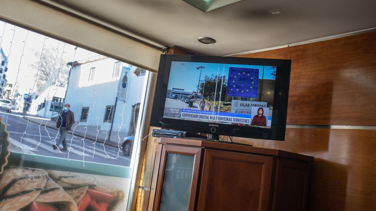 1. Una mujer ve la tele en un restaurante de Braganza. 2. Acceso a la zona navideña de la localidad portuguesa. 3. Puesto fronterizo entre Quintanilha y San Martín del Pedroso. 4. Un supermercado situado en Miranda do Douro. 5. Varias personas, en una terraza situada en Braganza. 6. Un hombre pasea por la calle mientras el telediario informa sobre las medidas contra el avance del COVID.  | Emilio Fraile