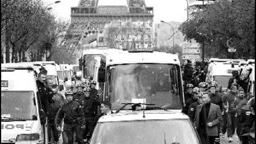 Las fuerzas de seguridad custodian el furgón donde viaja la llama olímpica por las calles de París. / jacky naegelen