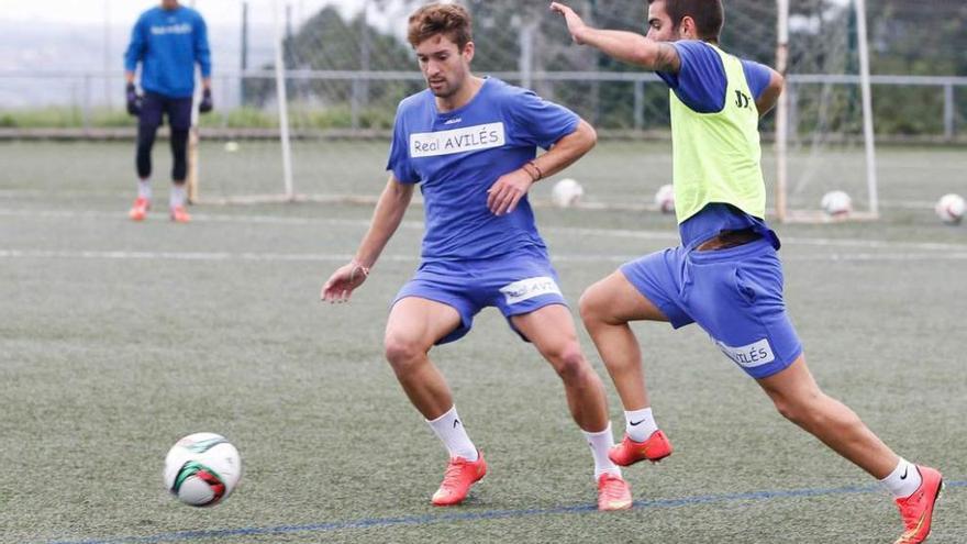 Luismi y Marcos Torres disputan un balón en un entrenamiento.