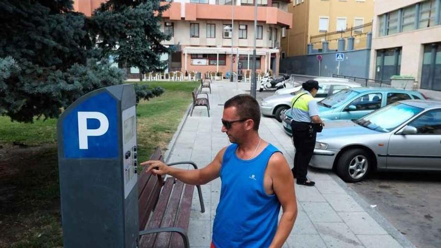 Un hombre extrae un tíquet de la zona azul en una de las calles de la capital.