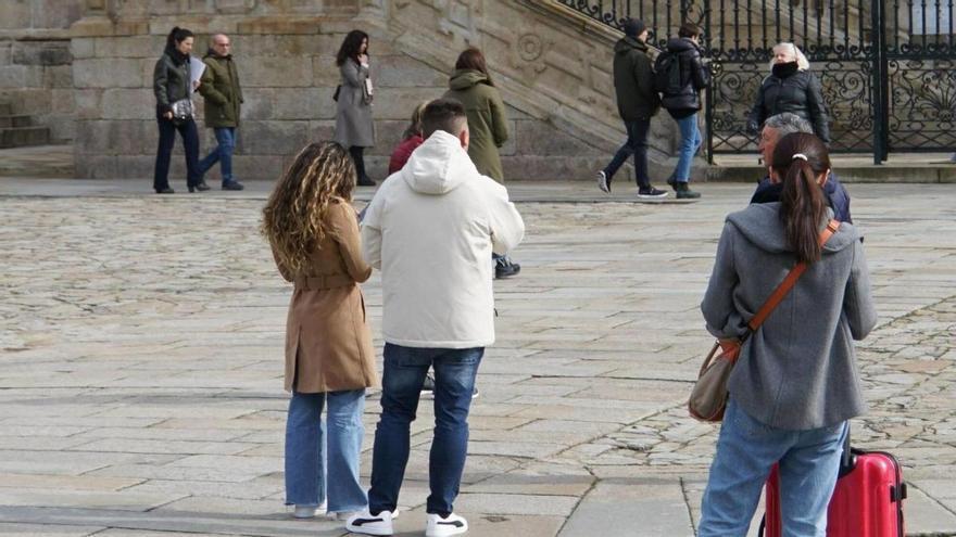 Turistas esta semana en la Praza do Obradoiro.  | FOTO: JESÚS PRIETO.