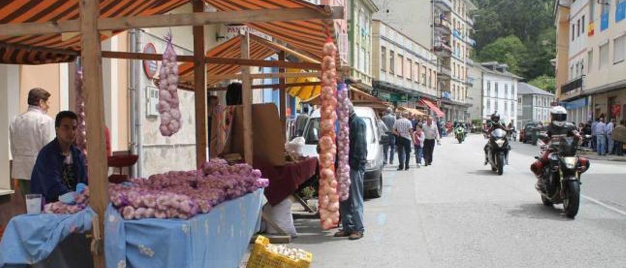 La travesía principal de Trevías, ayer, con los puestos del mercado artesanal y las motos.