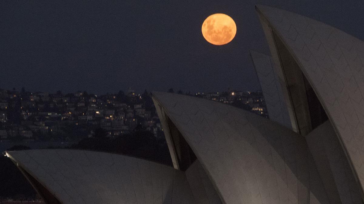 Superluna rosa tras el tejado de la Ópera de Sídney, este martes.