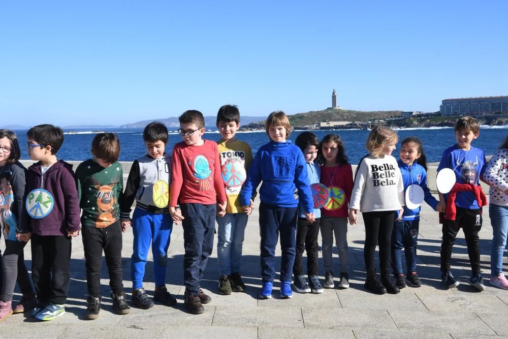 Escolares de A Coruña conmemoran el Día de la Paz con una cadena humana que recorrió el paseo marítimo hasta la Torre de Hércules y la lectura de un manifiesto.