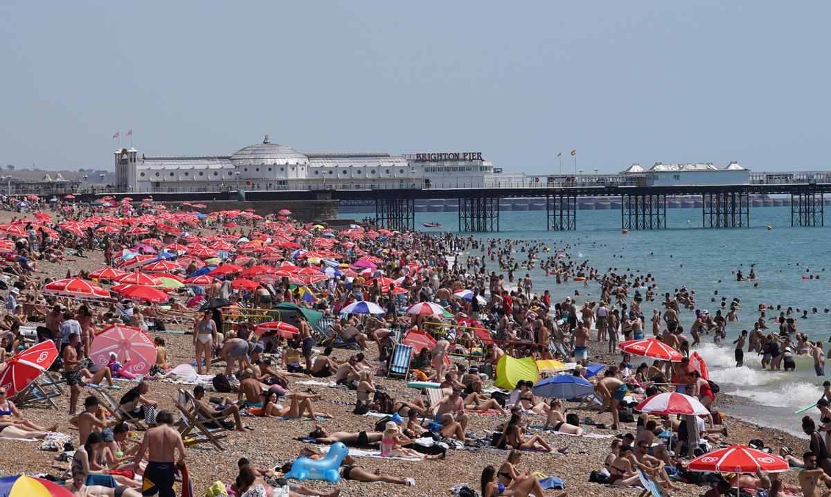 La gente se agolpa en la playa de Brighton mientras los británicos experimentan el día más caluroso registrado en el Reino Unido con temperaturas previstas de 40 grados.