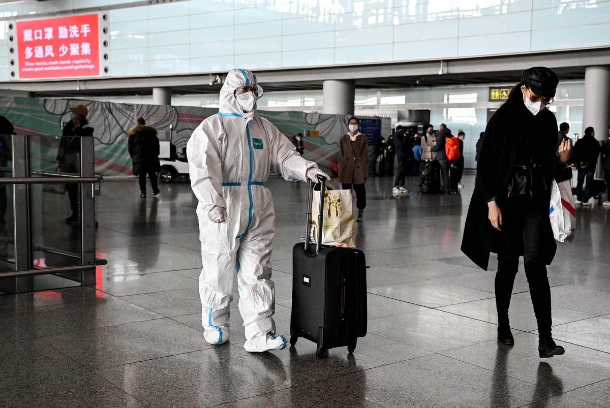 Un pasajero, con un equipo de protección personal, camina en el área de llegadas del Aeropuerto Internacional Capital en Beijing.