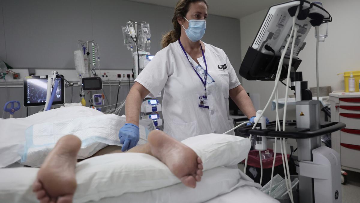 Una sanitaria atiende a un paciente de coronavirus en una UCI en Madrid.